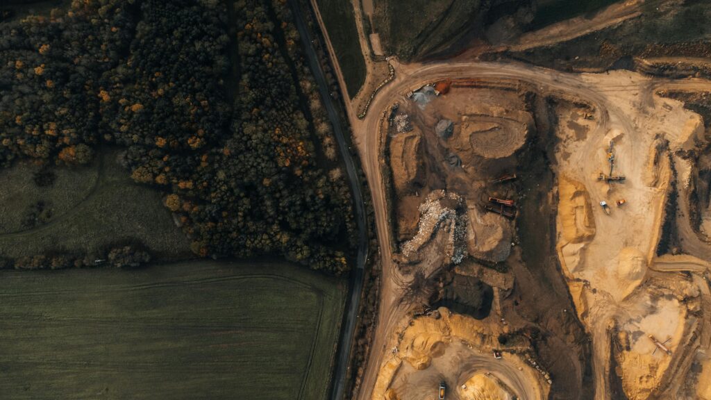 Aerial view of a quarry site next to a forest in England, highlighting industry impact on nature.